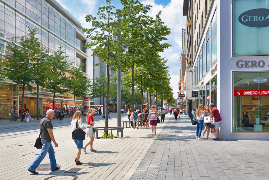 Mannheim, Germany -People walking through city center of Mannheim with people and various shops